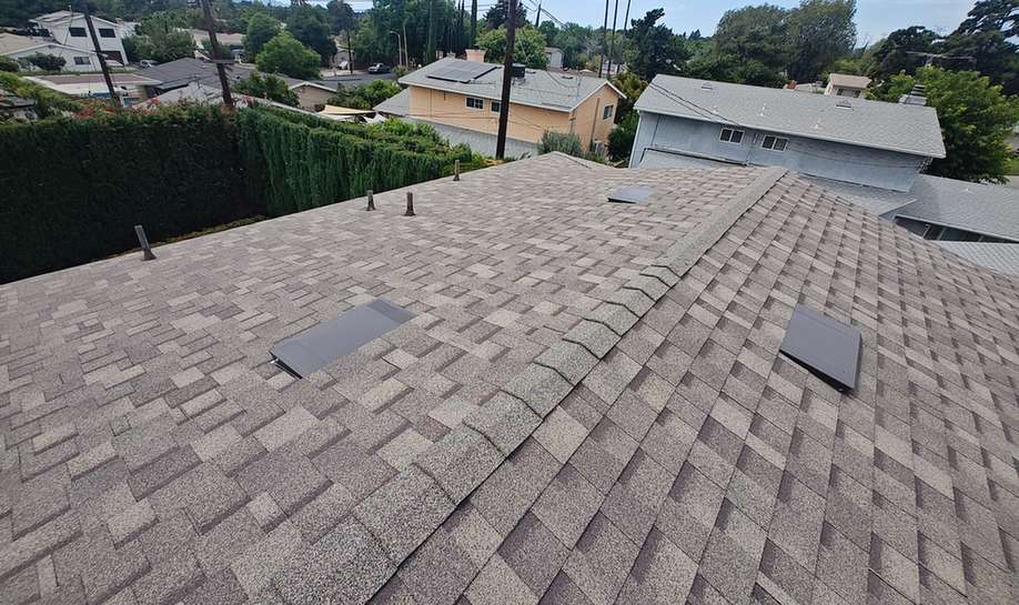 Finished brown-gray shingle roof with vents and ridge details, featured on the El Monte roofing page.