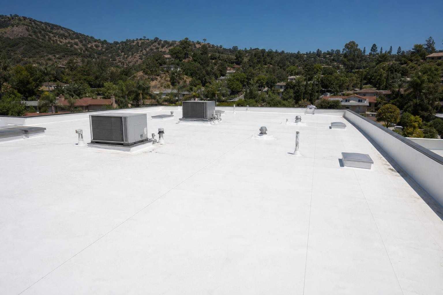 A broad commercial low-slope roof viewed from above, shown near the beginning of the second half of the Pasadena emergency roof repair page.
