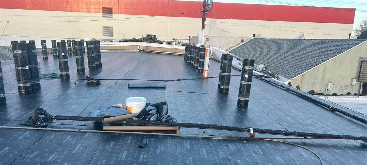 Broad commercial low-slope roof during active roofing work, featured on the Los Angeles roofing page.