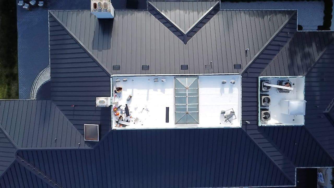 Aerial view of a finished standing-seam metal roof around a low-slope center, featured on the East Pasadena roofing page.