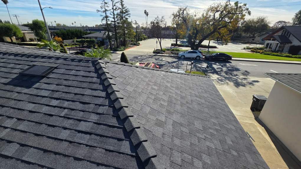 Finished dark architectural-shingle roof above a street, featured on the Rosemead roofing page.