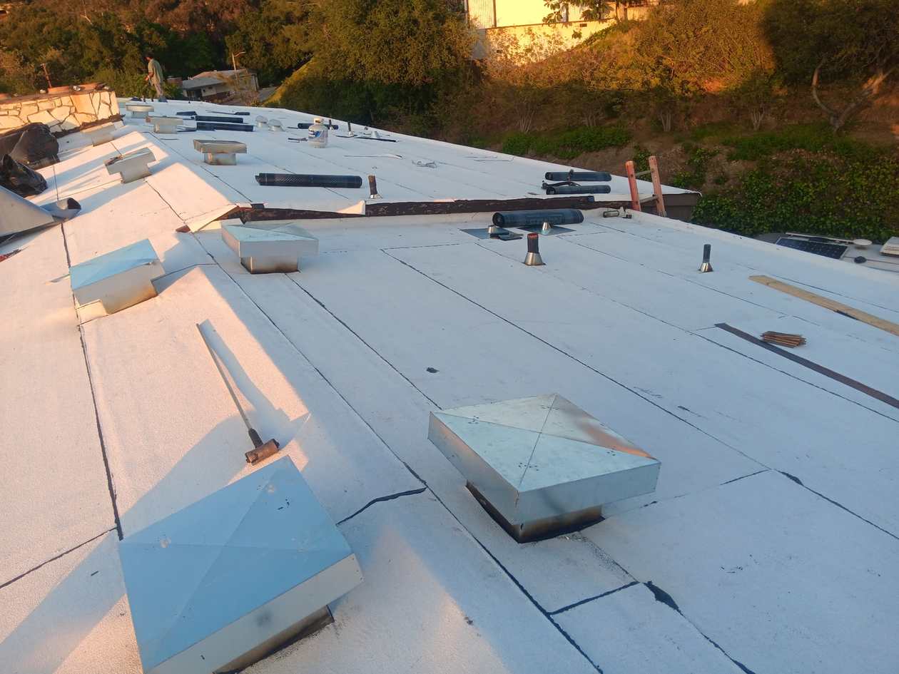 Broad white low-slope roof field with penetrations, shown near the beginning of the second half of the Arcadia roofing page.