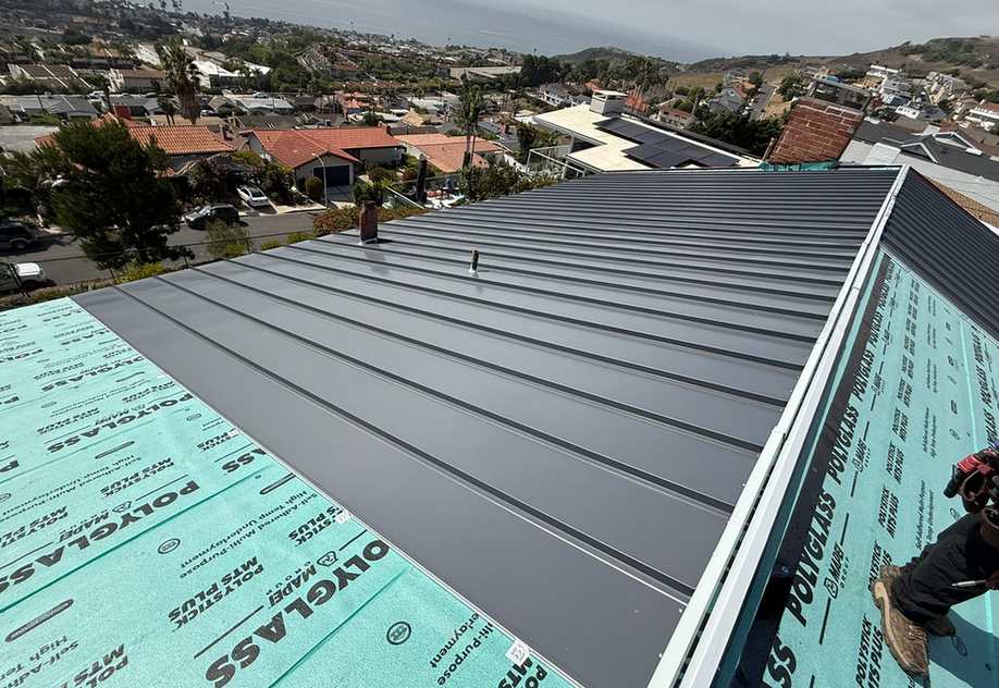 Broad standing-seam metal roof plane during installation, shown near the beginning of the second half of the Temple City roofing page.
