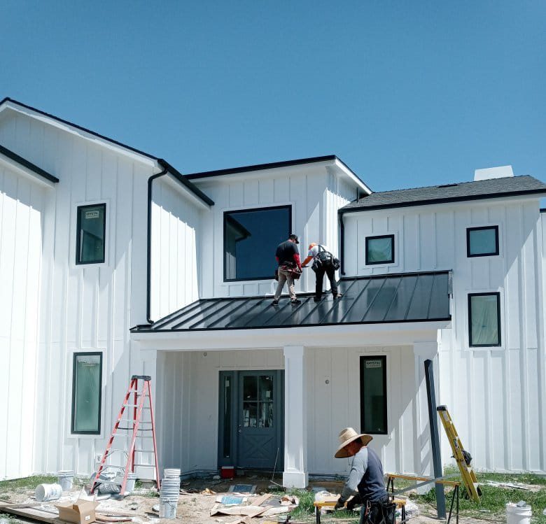 Roofers installing metal panels on a residence, shown near the beginning of the second half of the Rosemead roofing page.