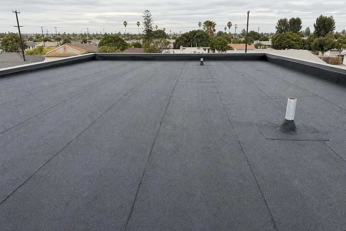 A finished low-slope roof on a residential building, shown near the beginning of the second half of the El Monte roofing page.