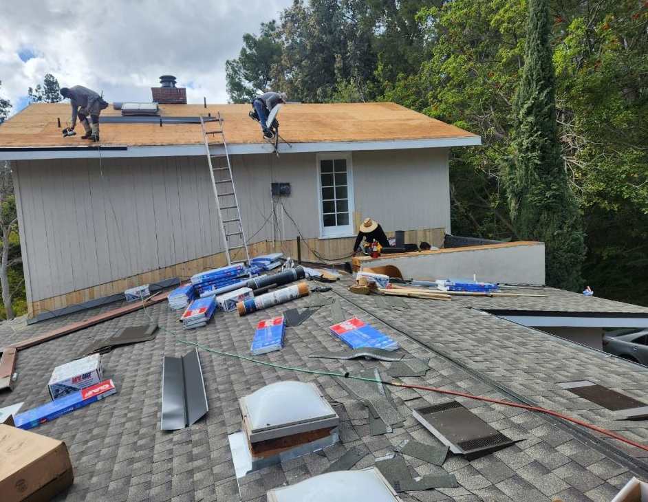 Active roofing work across a broad roof deck, shown near the beginning of the second half of the San Gabriel roofing page.