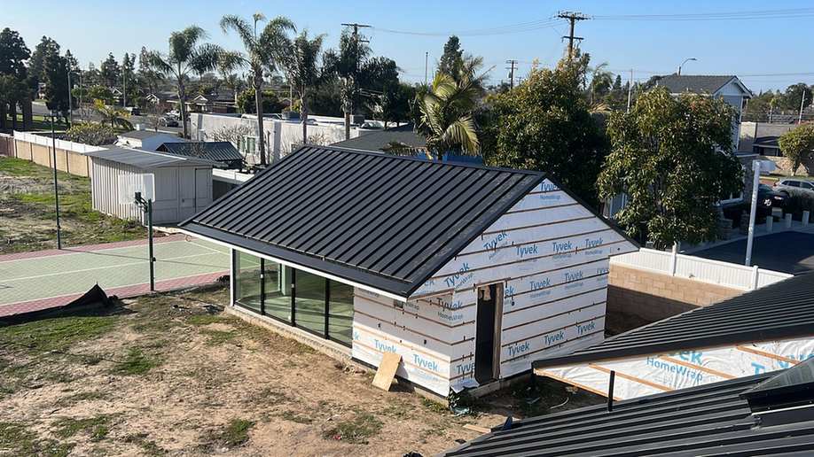Finished standing-seam metal roof on a residential structure, shown near the beginning of the second half of the East San Gabriel roofing page.