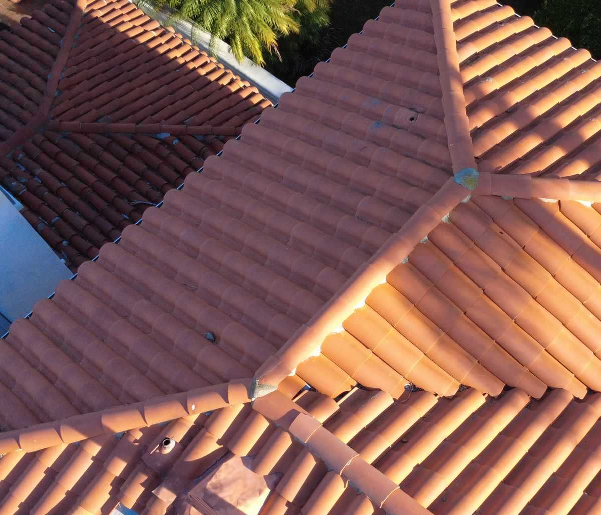 Aerial view of terracotta barrel-tile roof planes, shown near the beginning of the second half of the Pasadena roof installation page.